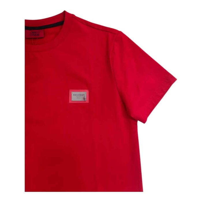 559 150 C 1 rotated | The Enrico Coveri Mini Metal Logo T-Shirt in Red is a bold yet refined staple, crafted from premium cotton that provides exceptional comfort and breathability for all-day wear. With a sleek mini metal logo on the chest, this T-shirt brings a subtle touch of elegance to its vibrant red color, making it versatile enough to pair with casual jeans or smart-casual chinos. Its modern slim fit is tailored to enhance the body’s natural shape while allowing full freedom of movement, showcasing Enrico Coveri's commitment to quality and sophisticated style