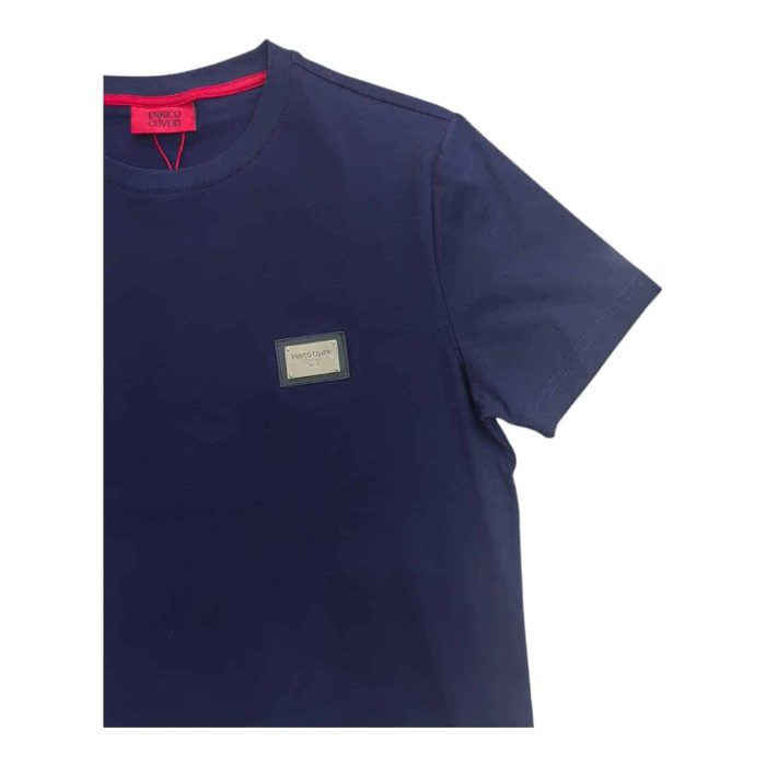 559 151 C 1 rotated | The Enrico Coveri Mini Metal Logo T-Shirt in Navy combines refined style and luxurious comfort, crafted from high-quality cotton that feels soft and breathable for all-day wear. Featuring a subtle mini metal logo on the chest, this T-shirt offers a touch of sophistication that enhances the rich navy color, making it versatile for both casual and smart-casual looks. With a modern slim fit that flatters the body while allowing freedom of movement, this T-shirt exemplifies Enrico Coveri’s dedication to timeless design and quality craftsmanship.