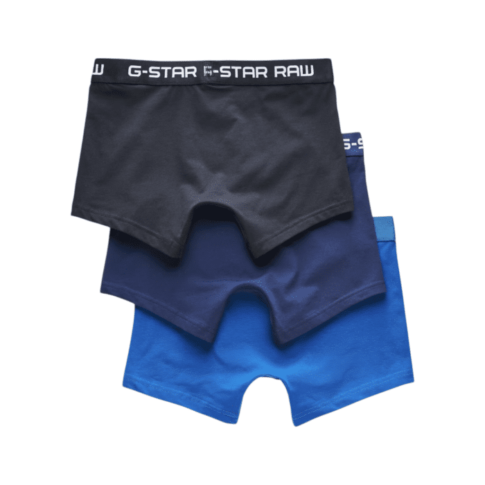 596 2A | The G-Star Classic Trunks 3-Pk in multiple blue colours offer a snug fit that ensures all-day comfort, featuring a sewn-in pouch for added support and short legs that stay in place without riding up. Made from a blend of 95% organic cotton and 5% elastane, these classic trunks provide a super stretch for optimal flexibility and shape retention, while the jersey knit fabric feels soft to the touch and is breathable for maximum comfort. With the signature G-Star RAW elastic waistband, this set of three delivers reliable support, combining style, comfort, and sustainability in every pair.