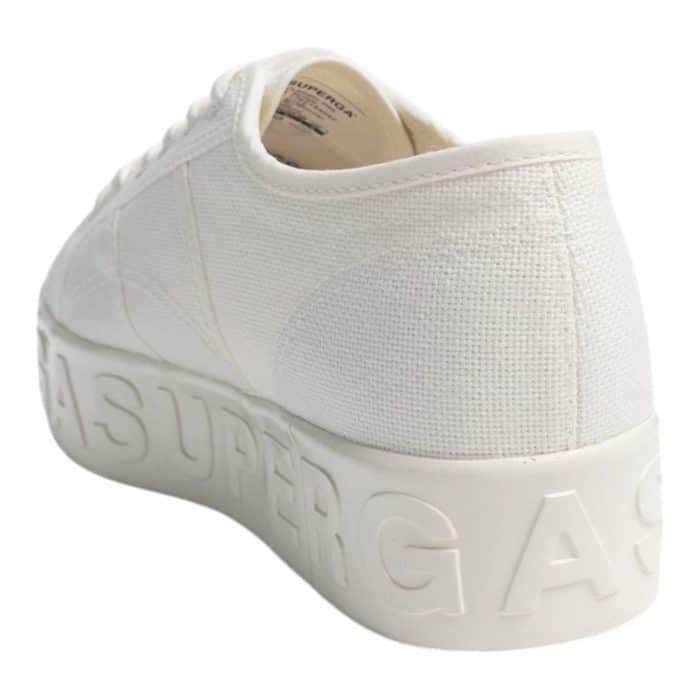 556 22 C | The Superga 2790 Shiny 3D Lettering Total White Avorio effortlessly combines minimalist elegance with modern flair, featuring a clean all-white design accented by bold, shiny 3D lettering on the side for a stylish touch. Its 1.5-inch platform sole provides a subtle lift while ensuring long-lasting comfort and stability, making it ideal for all-day wear. Crafted from premium cotton canvas with a durable rubber sole, this versatile sneaker offers breathability, durability, and a chic, contemporary look that pairs perfectly with any outfit.