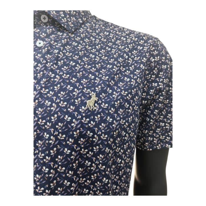 298 11 C | The Polo Shirt SS Floral Print seamlessly combines timeless sophistication with a modern twist, featuring an intricate floral design that exudes elegance and versatility for various occasions. Crafted from a soft, breathable cotton blend, this shirt offers exceptional comfort and durability, ensuring you stay cool and stylish throughout the day. With its tailored fit, classic collar, and short-sleeve design, it provides a polished yet relaxed look that pairs effortlessly with everything from chinos to jeans, making it a wardrobe essential.